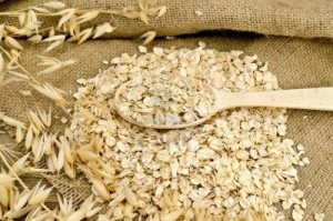 oat-flakes-with-a-wooden-spoon-stalks-of-oats-on-sacking-and-wooden-board